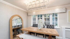 A dining room with a wooden table, bench, and chairs. There is a chandelier above the table and a large mirror on the wall. - New Listing Special Discount! (Greater Manchester)