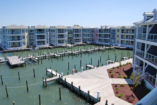 A waterfront hotel with multiple balconies, a dock area, and a landscaped garden.