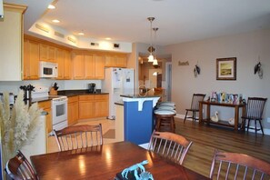 A modern kitchen with wooden cabinets, a microwave, stove, and a blue island counter.