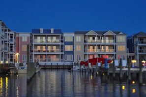 A waterfront hotel with multiple-story buildings, balconies, and a dock with boats.