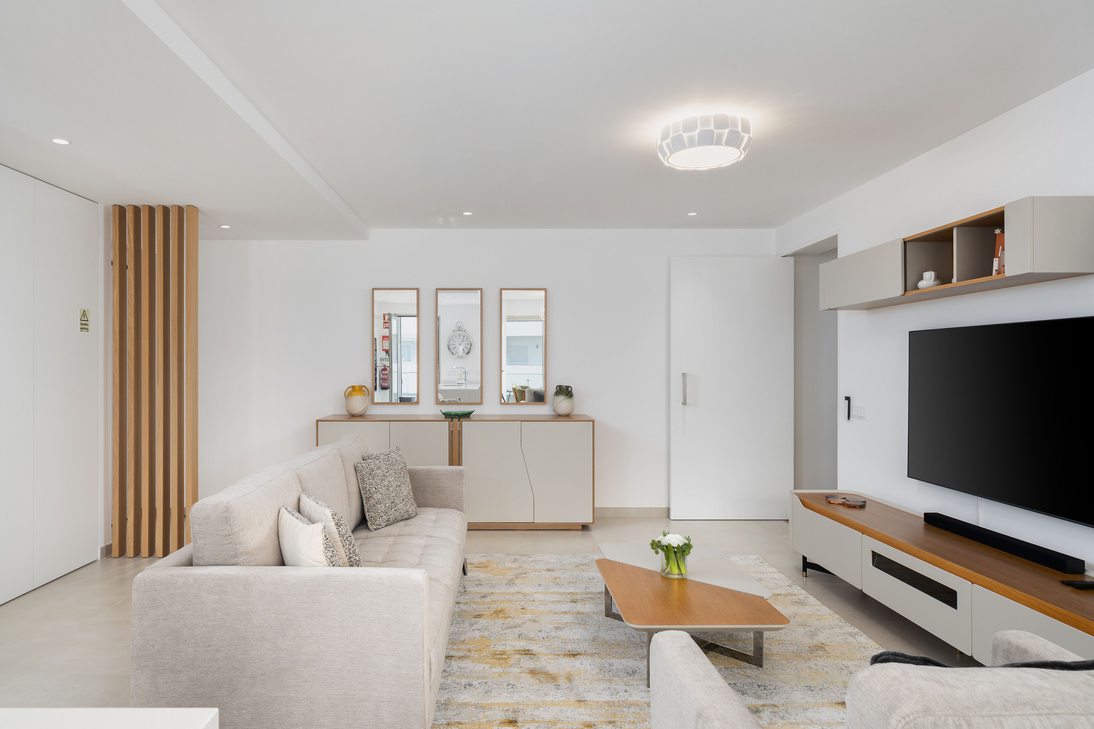 Un salon moderne avec un canapé, une table basse et un téléviseur.