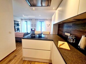 A modern kitchen with a central island, white cabinetry, and a dark backsplash. - Luxury 2 bedrooms with Parking&Terrace (Luxembourg City)