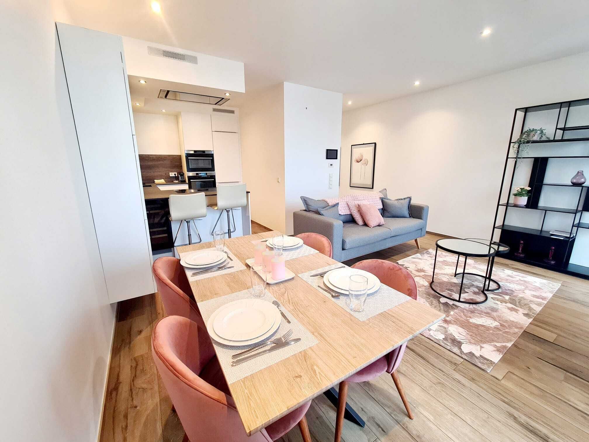 Um apartamento moderno com sala de jantar, cozinha e sala de estar.