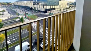 Ein modernes Gebäude mit Glasfassade, einer Fußgängerampel und einer belebten Straße mit Autos.