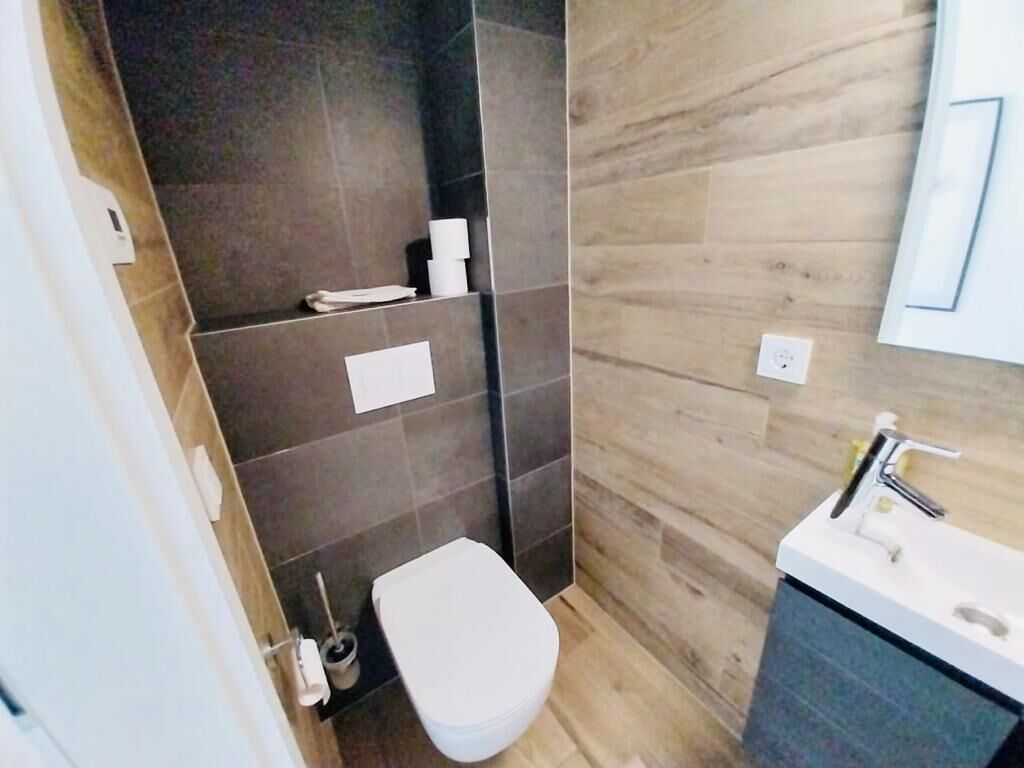 A bathroom with a toilet, sink, and towel rack.