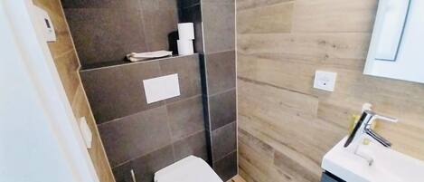 A bathroom with a toilet, sink, and towel rack.