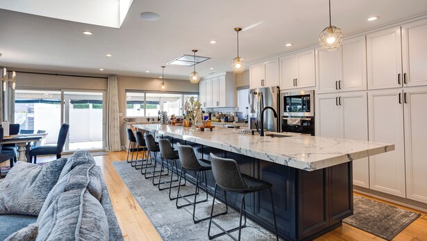 A modern kitchen with a large island, bar stools, and pendant lighting. - Fletcher Hills luxury, Sunset View, 4 BR, Saltwater Pool and Spa (El Cajon)