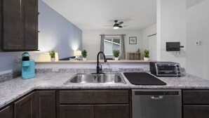 A modern kitchen with a double sink, a toaster, and a dishwasher. - Modern Studio Apartment in the heart of Festus (Festus)