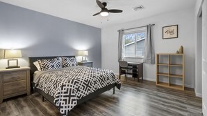 A bedroom with a bed, nightstands, a desk, and a chair. - Modern Studio Apartment in the heart of Festus (Festus)