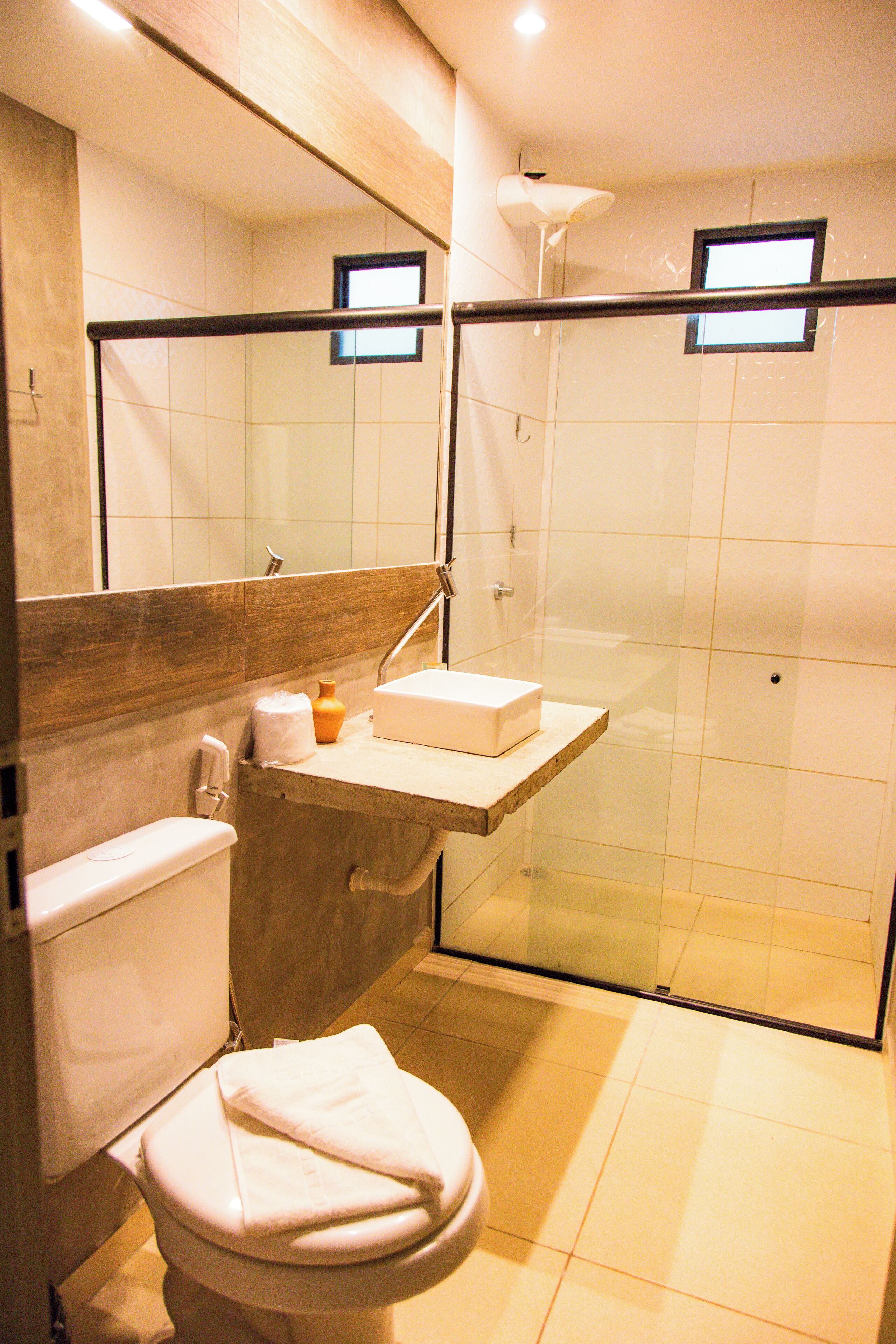 A bathroom with a toilet, sink, and shower area.