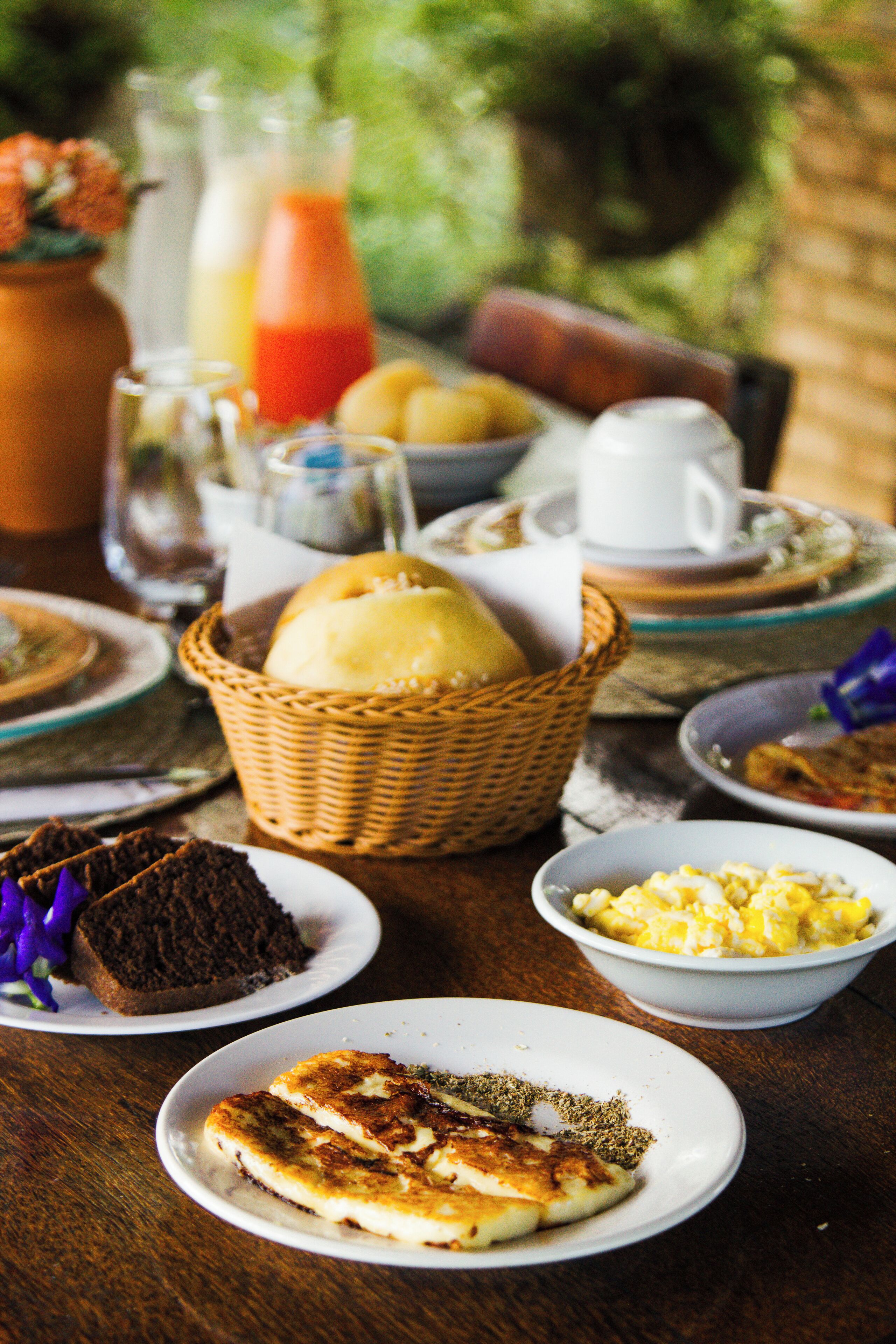 Une table de petit-déjeuner avec divers plats, notamment du pain, des œufs et une boisson.
