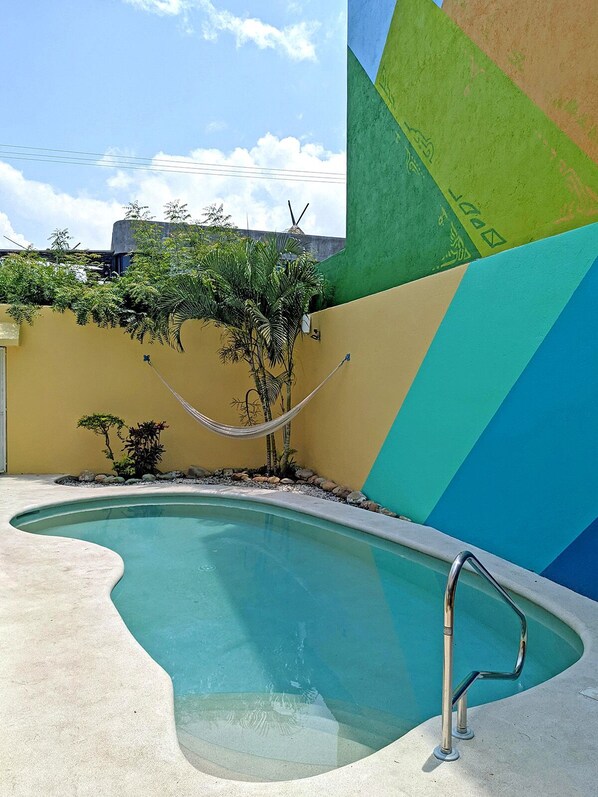 A swimming pool with a metal ladder, surrounded by a yellow wall with a geometric mural. - 2BR - Fast Internet, Near Beach, Pool, King Beds, ACs (Puerto Escondido)