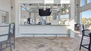 A spacious outdoor bar area with a high ceiling, white walls, and a tiled floor. - Special Offer! Frozen Themed Condo on the top floor lake view close to Disney  (Kissimmee)