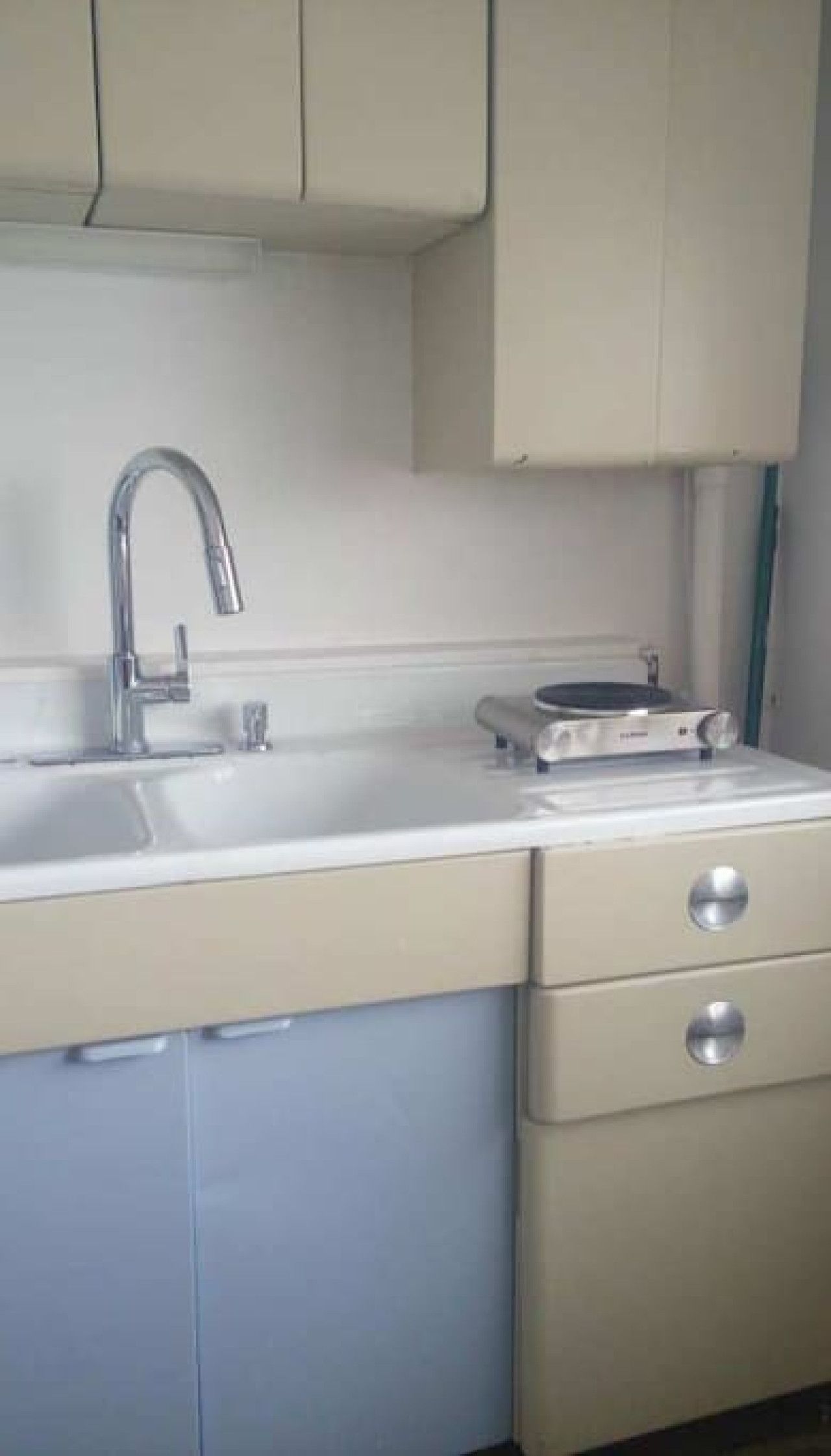 Cozinha com pia, lava-louças e um eletrodoméstico na bancada.