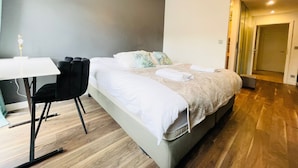 Una habitación de hotel moderna con una cama grande, un escritorio y una silla.