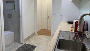 A compact kitchen with a sink, a small countertop, and a microwave.
