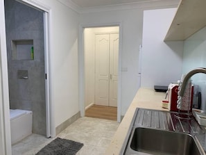 A compact kitchen with a sink, a small countertop, and a microwave.
