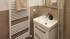 A bathroom with a white sink, a mirror, and a towel rack.
