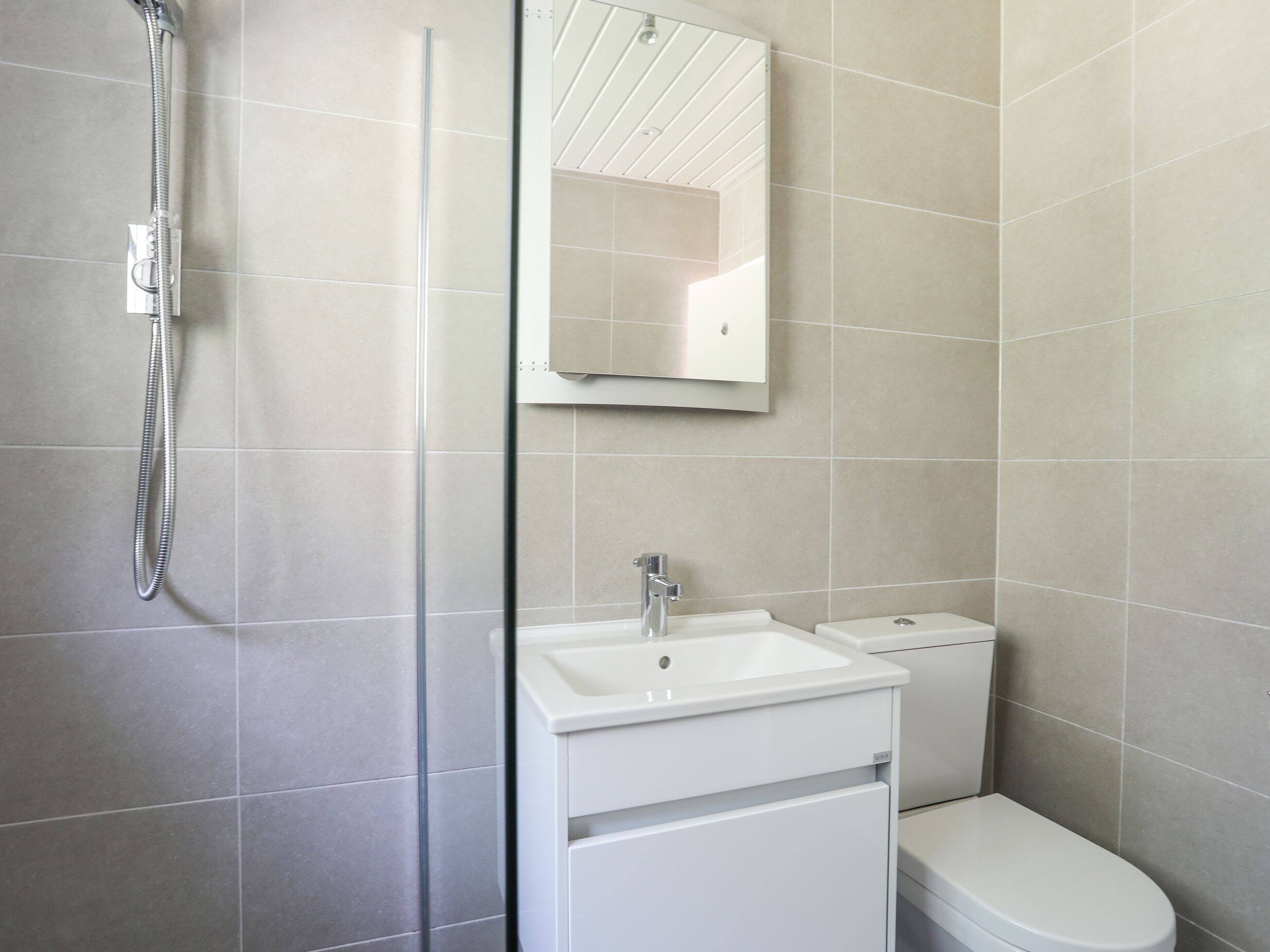 Un baño moderno con ducha, lavabo e inodoro.
