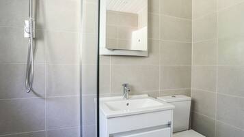 Un baño moderno con ducha, lavabo e inodoro.