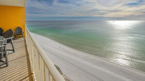 A balcony with a view of a beach and ocean.
