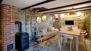 Un salon confortable avec une cheminée, un canapé, une table à manger et un téléviseur.