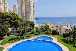 A swimming pool with a view of the sea and tall buildings in the background. - PINTOR SOROLLA sea view apartment (Benidorm)