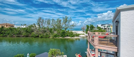 A waterfront property with a dock, outdoor seating, and a view of the ocean.