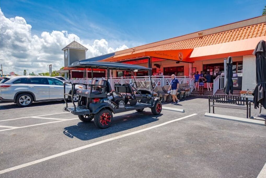 A parking lot with a vehicle and a building with a red awning.