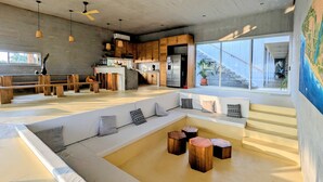 Ein modernes Interieur mit Küche, Sitzgelegenheit und großen Fenstern.