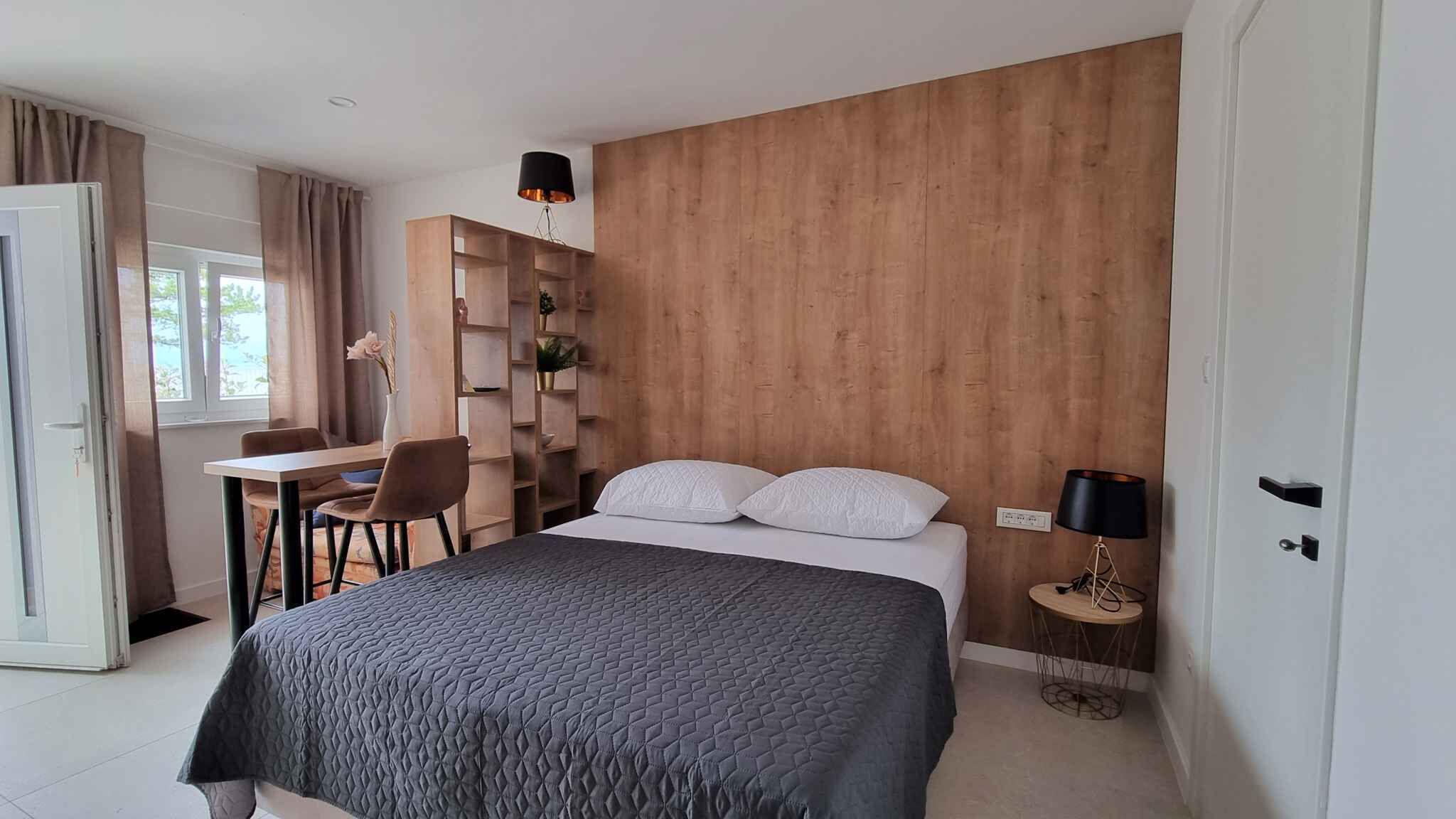 Een slaapkamer met een bed, een bureau en een stoel.