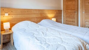Ein Doppelbett mit Holz-Kopfteil und zwei Nachttischlampen.