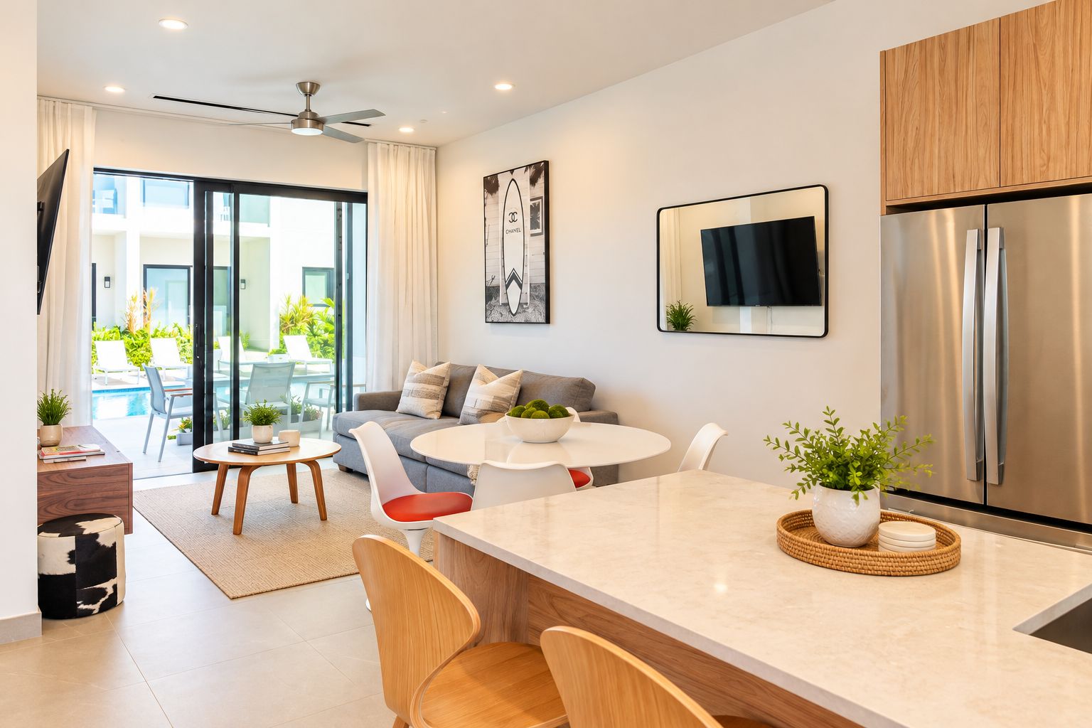 Una cocina moderna con una isla central, electrodomésticos de acero inoxidable y un comedor con una mesa redonda y sillas.