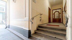 Un escalier avec une rampe, une moquette rouge et une porte avec un cadre en bois.