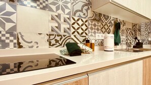 A kitchen with patterned tiles, a countertop, and a sink.