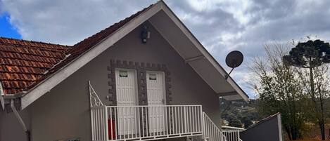 Un bâtiment à deux étages, doté d’un toit recouvert de tuiles rouges, d’un balcon et d’une antenne parabolique.