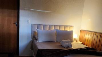 Un dormitorio con dos camas, techo de madera y un tapete mullido.