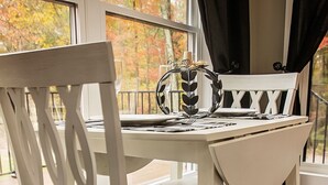 A white dining table with chairs, a vase, and a candle. - Cozy private getaway built for couples to reconnect !!  (West Union)