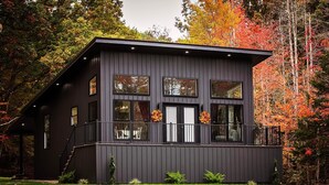 A modern two-story house with a balcony, surrounded by autumn foliage. - Cozy private getaway built for couples to reconnect !!  (West Union)