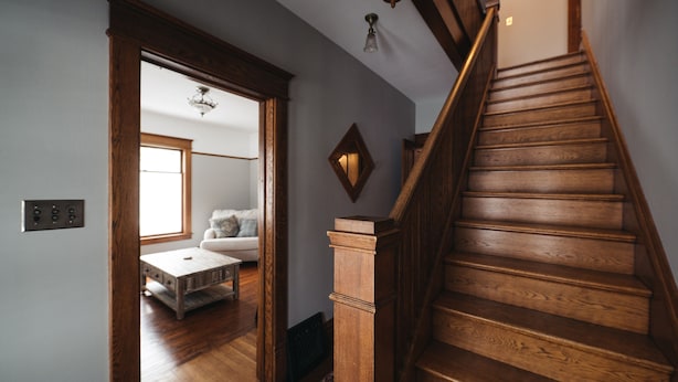 A wooden staircase with a handrail and a light fixture above it. - 4BDR Broomhead Farmhouse Main House (Williamsburg)