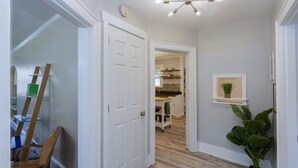 A hallway with a white door, a ceiling light fixture, and a potted plant. - Music City House, 4 miles to BDWY, Free Parking (Nashville)
