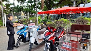 A man renting a blue and a red motorcycle. - Victory View Rayong Beach (Rayong)