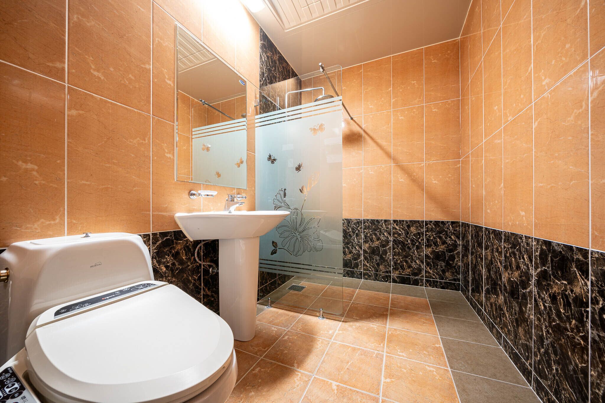 A modern bathroom with a toilet, sink, and shower.