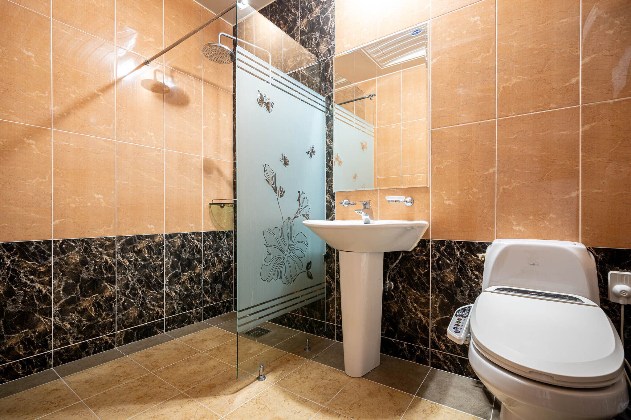 A bathroom with a toilet, sink, and shower.