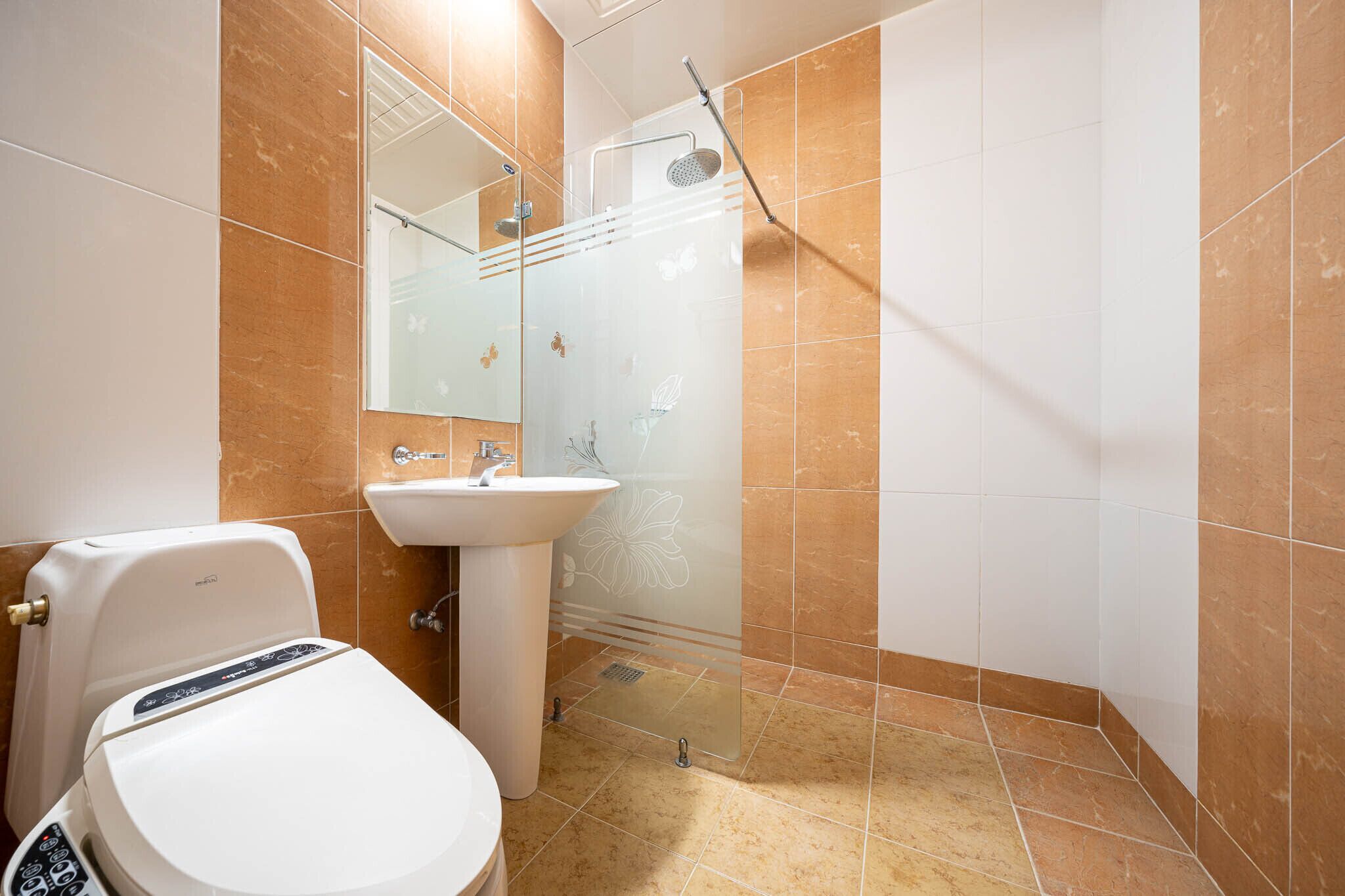 Un baño con inodoro, lavamanos y ducha.