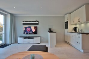 A modern kitchen with white cabinets, a built-in oven, and a coffee maker. - Haus Schäfer - Haus Schäfer Appartement 8 (Timmendorfer Strand)