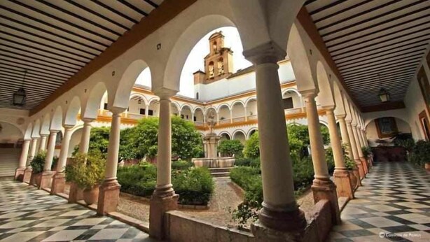 A courtyard with a checkered floor, arches, columns, and a central fountain. - AREVALO CENTER APARTMENT Free parking (Lucena)