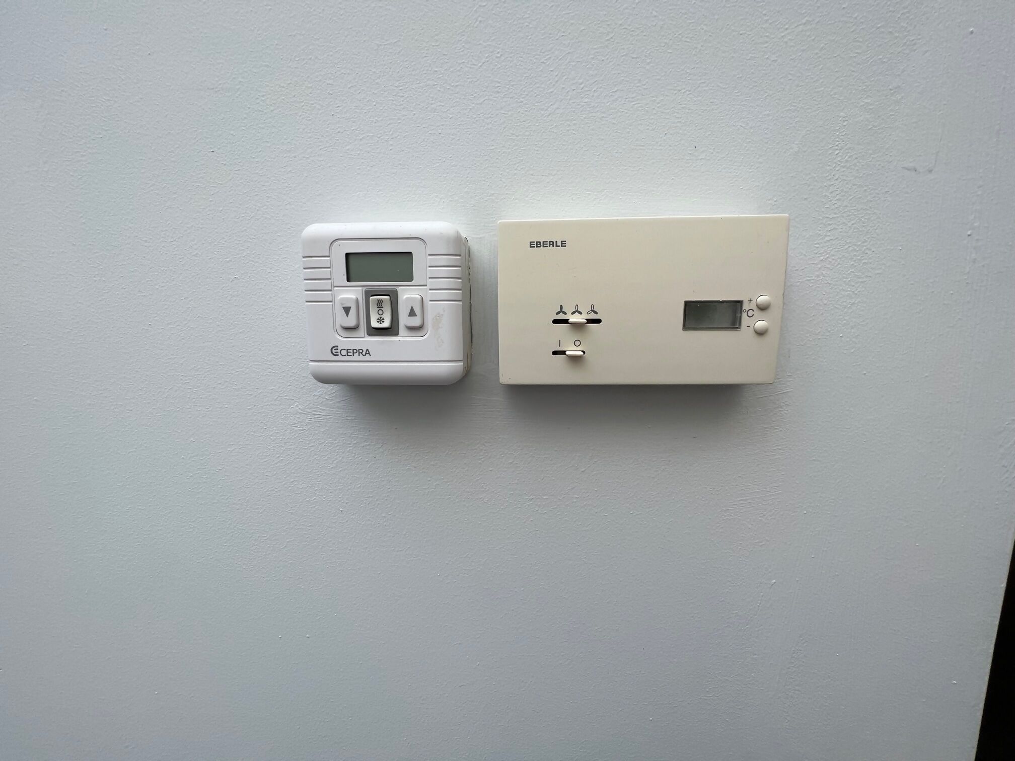 Un termostato y un panel de control en una pared.