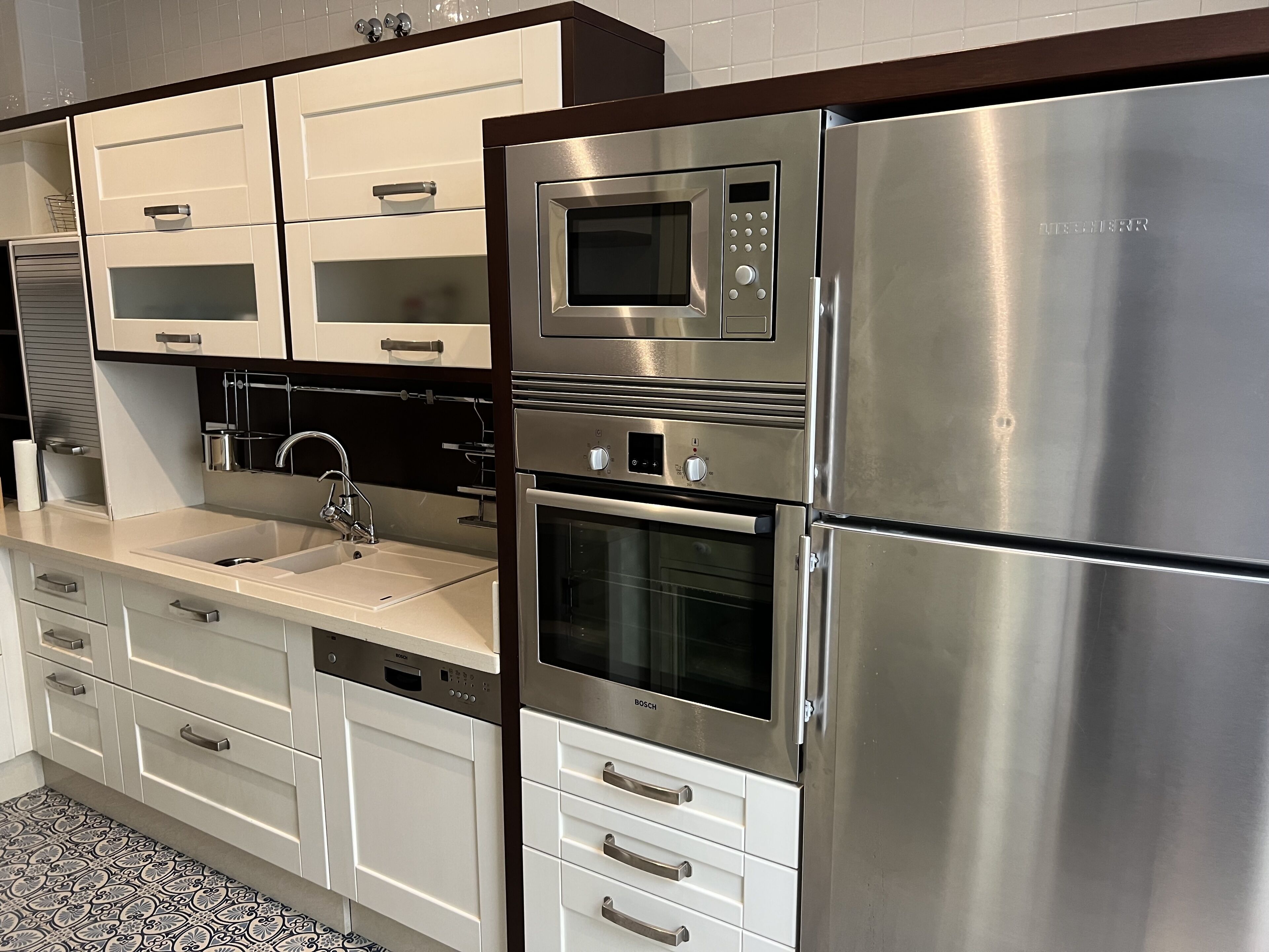A modern kitchen with stainless steel appliances, including a refrigerator, oven, and microwave.