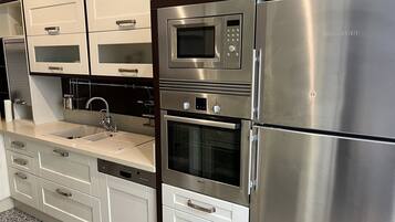 A modern kitchen with stainless steel appliances, including a refrigerator, oven, and microwave.